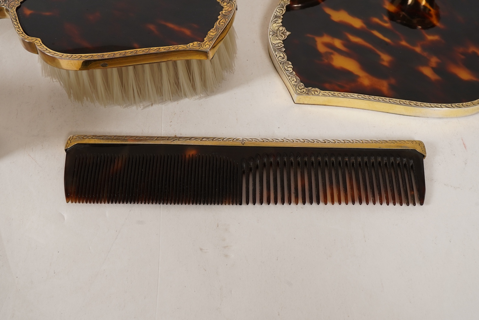 A mid 20th century continental eight piece gilt white metal and tortoiseshell mounted dressing table set